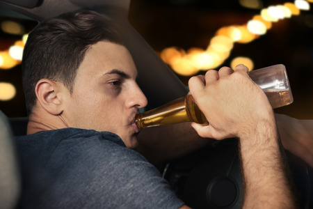 Man drinking alcohol in car