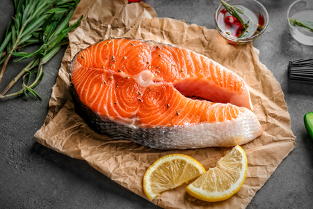 Fresh salmon steak on parchment paperの写真素材