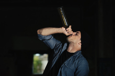 Man drinking alcohol in abandoned buildingの写真素材