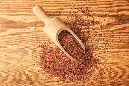 Red quinoa and scoop on wooden backgroundの写真素材