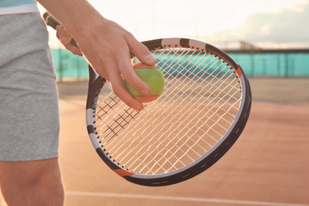 Young man playing tennis on courtの写真素材