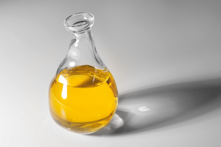 Glass jug with cooking oil on white backgroundの写真素材
