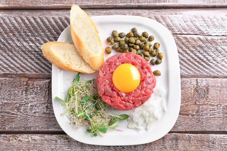 Delicious steak tartare with yolk on plateの写真素材