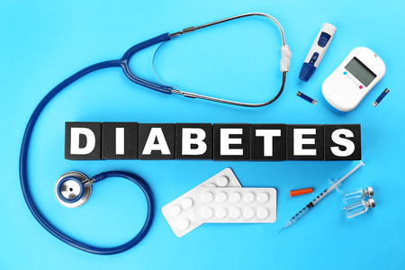 Composition with medical stuff and word Diabetes made of cubes on color backgroundの写真素材