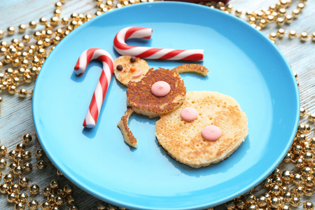 Plate with funny snowman from pancakes on table. Christmas conceptの写真素材