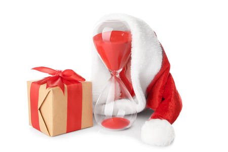 Hourglass with Santa hat and gift box on white background. Christmas countdown conceptの写真素材