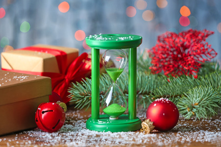 Hourglass and decorations against defocused lights. Christmas countdown conceptの写真素材