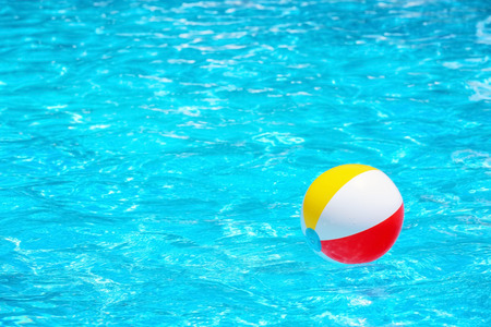 Colorful inflatable ball in blue swimming poolの写真素材