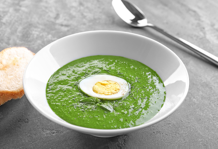 Plate with tasty spinach soup on tableの写真素材