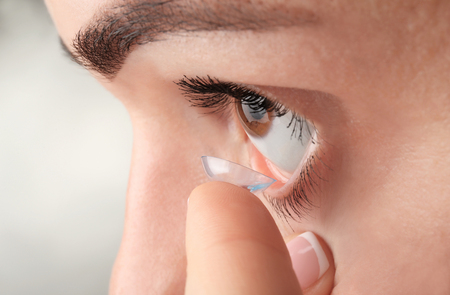 Young woman putting contact lens, closeupの写真素材