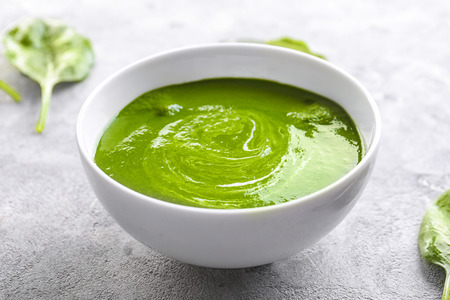 Bowl with tasty spinach soup on tableの写真素材
