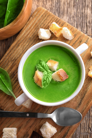 Tureen with delicious spinach soup on wooden tableの写真素材