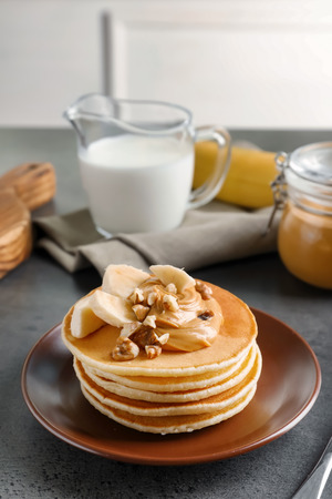 Plate with yummy banana pancakes on tableの写真素材