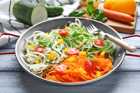 Frying pan with delicious vegetable spaghetti on tableの写真素材