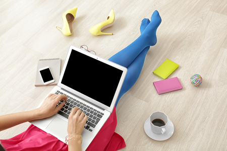 Young beauty blogger using laptop while sitting on floorの写真素材