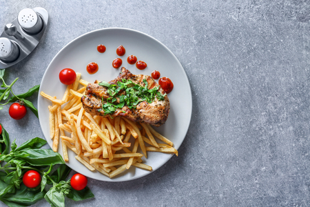 Plate with delicious grilled steak frites on kitchen tableの写真素材
