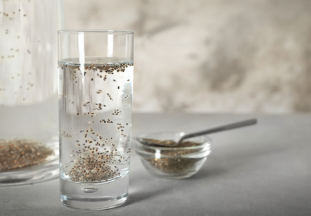 Glass of water with chia seeds on tableの写真素材