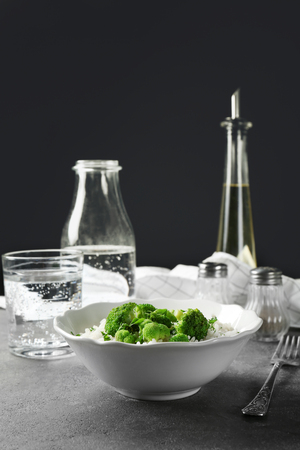 Bowl with rice and broccoli on tableの写真素材