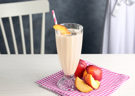 Glass of delicious smoothie with chia seeds and peaches on tableの写真素材