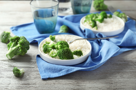 Plate with rice and broccoli on wooden tableの写真素材