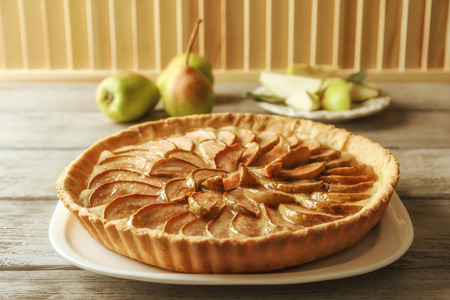 Plate with tasty pear tart on wooden tableの写真素材