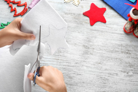 Little child sewing Christmas star from felt at tableの写真素材