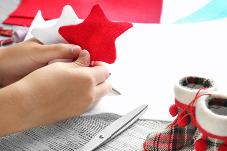 Little child holding Christmas stars from felt at tableの写真素材