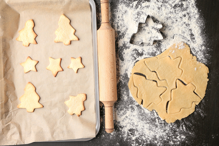 Raw dough and Christmas cookies on tableの写真素材