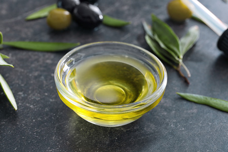Glass bowl with olive oil on dark backgroundの写真素材