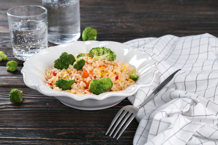 Plate with rice pilaf and broccoli on wooden tableの写真素材