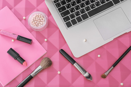 Composition with laptop and decorative cosmetics on color background. Beauty blogger concept