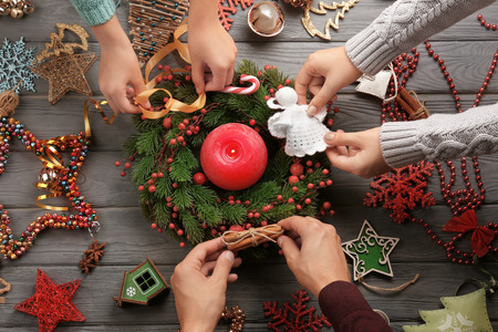 Family decorating Christmas wreath  on wooden backgroundの写真素材