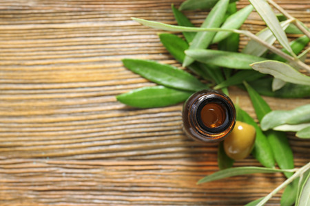 Glass bottle with olive oil on wooden tableの写真素材