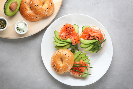 Plate with delicious salmon bagels on tableの写真素材