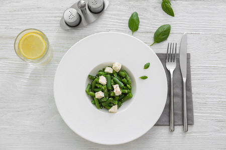 Plate with delicious green beans salad on wooden tableの写真素材