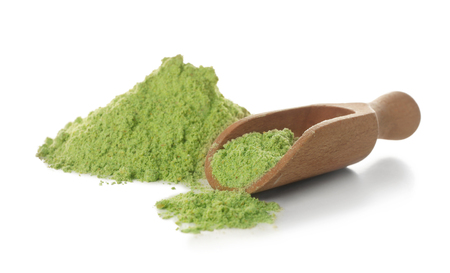 Wheat grass powder and wooden scoop on white backgroundの写真素材