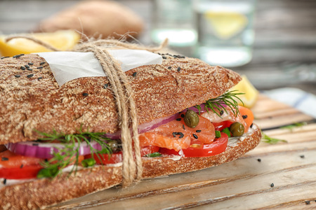 Tasty salmon sandwich with rye bread on wooden board, closeupの写真素材
