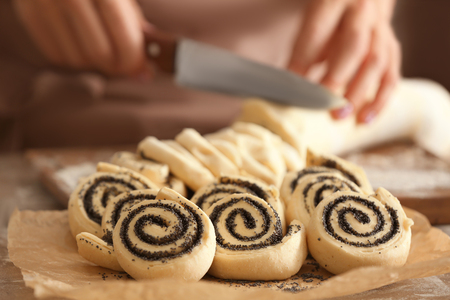 Raw rolls with poppy seeds and woman on backgroundの写真素材