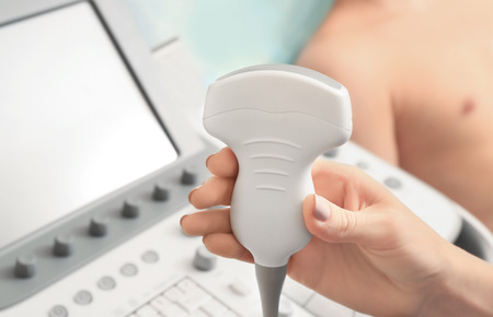 Hand of doctor with ultrasound equipment and blurred patient on backgroundの写真素材