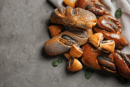 Tasty pastries with poppy seeds on grey backgroundの写真素材