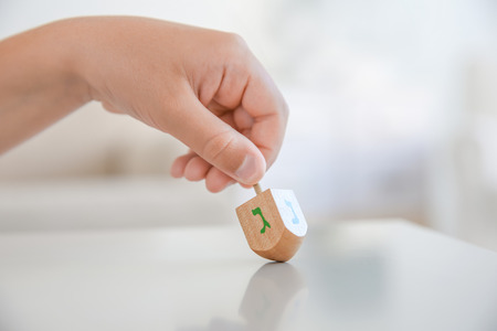 Jewish boy playing with dreidel at homeの写真素材