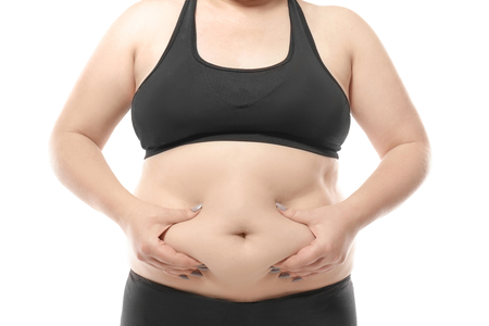 Woman touching fat on her belly against white background. Weight loss conceptの写真素材