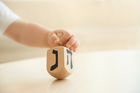 Jewish boy playing with dreidel at homeの写真素材