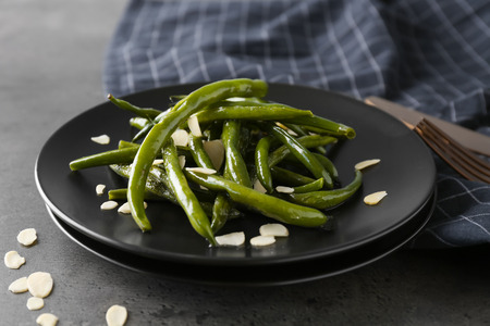 Plate with delicious green beans and almond on grey backgroundの写真素材