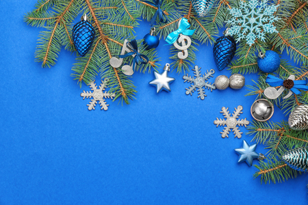 Beautiful composition with fir tree branches and decorations on color background. Christmas music conceptの写真素材