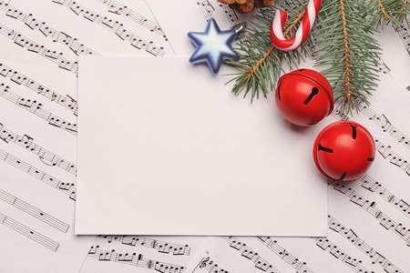 Beautiful composition with paper card and decorations on music sheets. Christmas songs conceptの写真素材