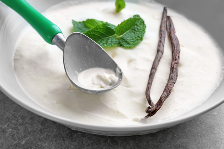 Bowl with tasty vanilla ice cream on tableの写真素材