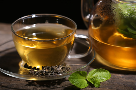 Cup with tasty mint tea on table, close upの写真素材
