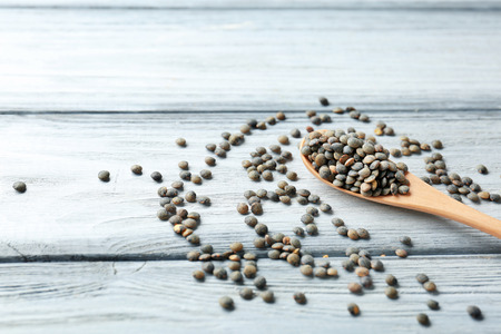 Spoon with healthy lentils on wooden backgroundの写真素材