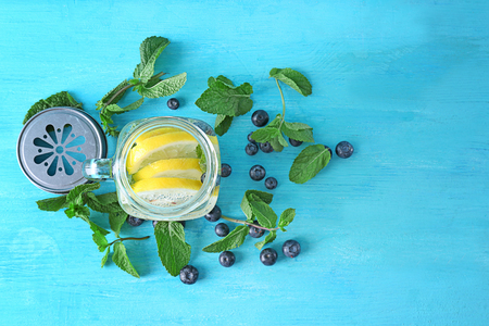 Mason jar of fruit infused water on wooden tableの写真素材